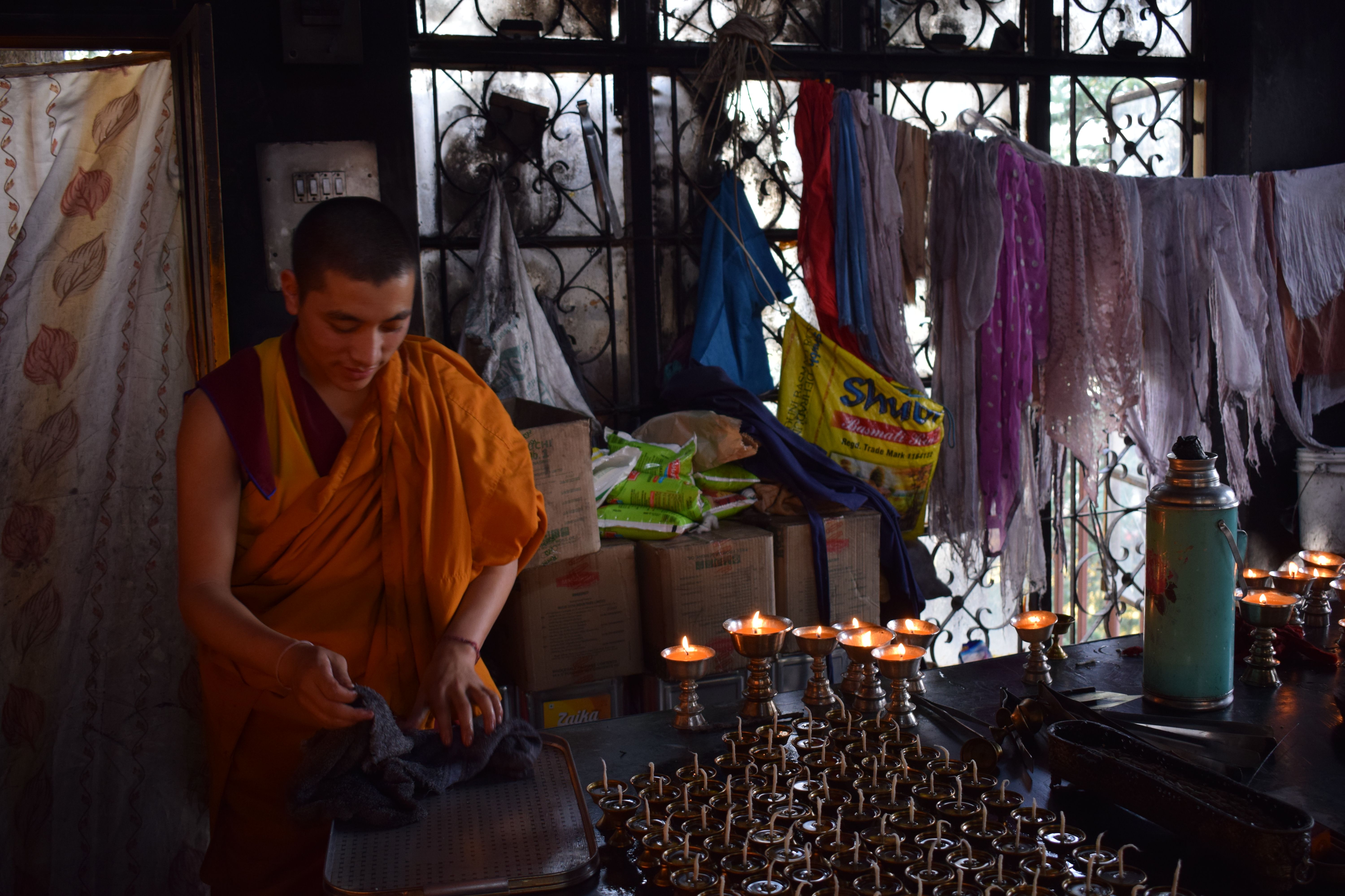 Monk lighting lamp inside Dalai Lama temple, Dharamshala, Kangra, Himachal Pradesh, India
